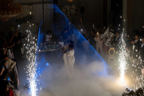 Performers in a festive atmosphere with sparks and smoke, creating an exciting scene.